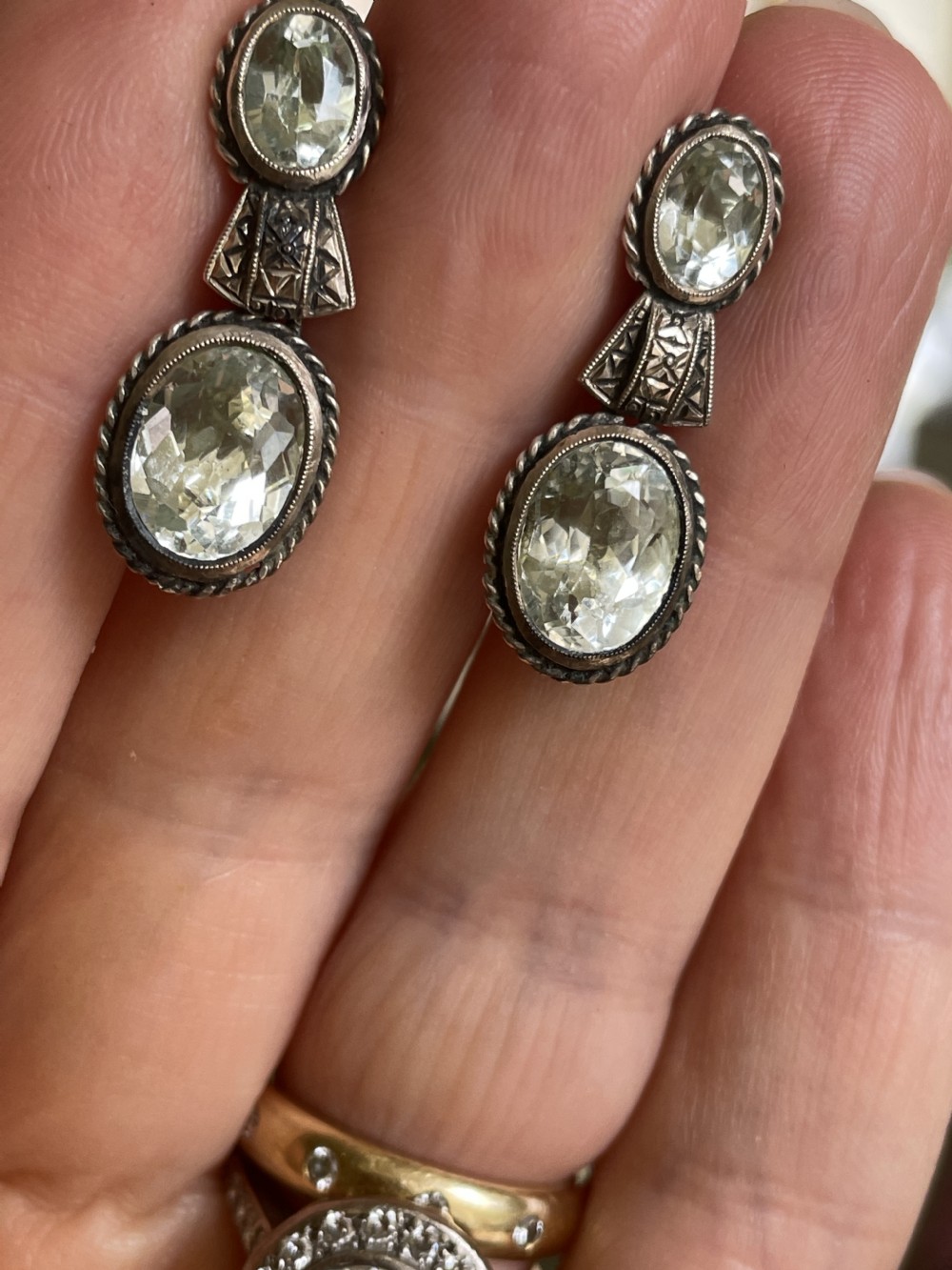 A pair of late 19th-century silver drop earrings set with two oval-cut pale blue aquamarines enclosed in rope-twist borders. View III