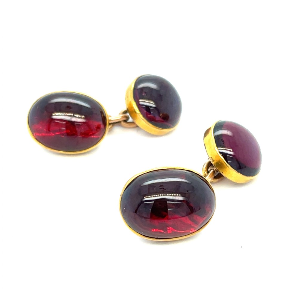 A pair of Victorian 9ct gold cufflinks set with polished oval cabochon garnet gemstones.
