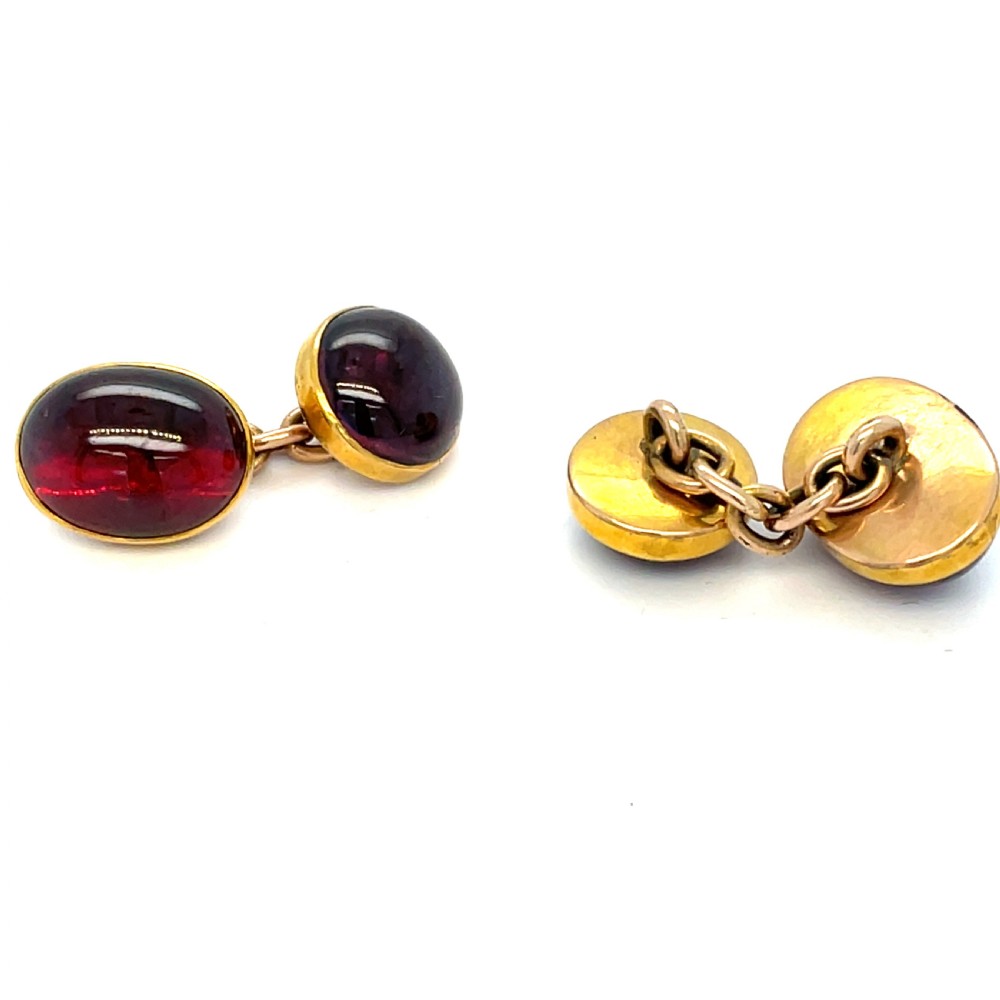 A pair of Victorian 9ct gold cufflinks set with polished oval cabochon garnet gemstones. View II