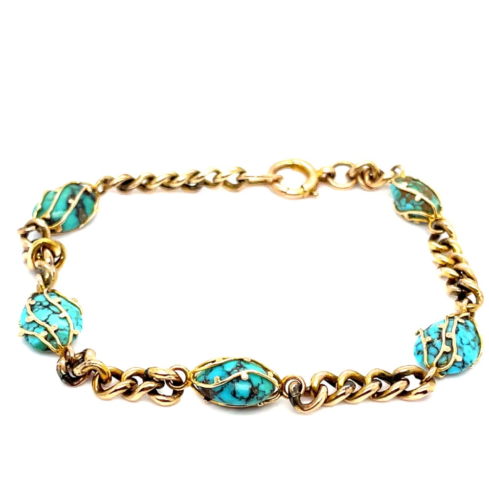 An Edwardian 9ct yellow gold link chain bracelet featuring oval turquoise cabochons encased in decorative gold wire settings.