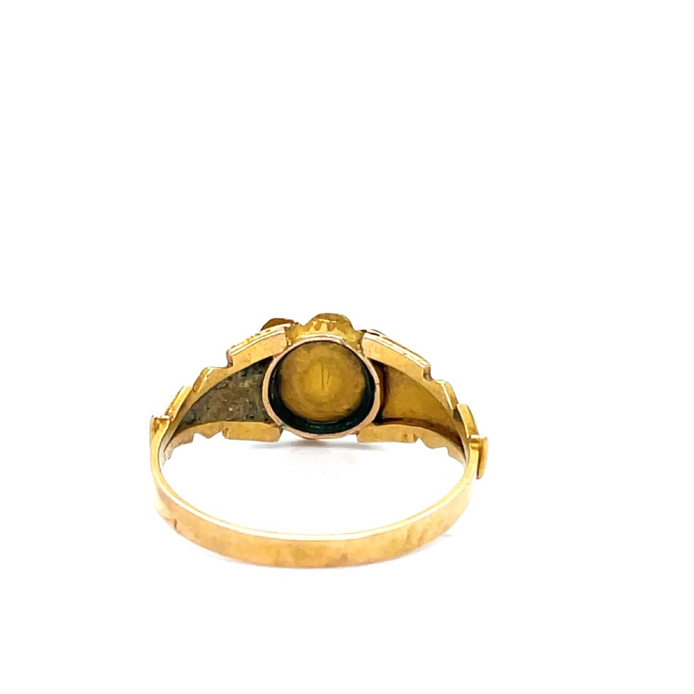 A Victorian 9ct gold mourning ring featuring a central blue agate surrounded by a floral cluster of seed pearls on an engraved gold band. View II