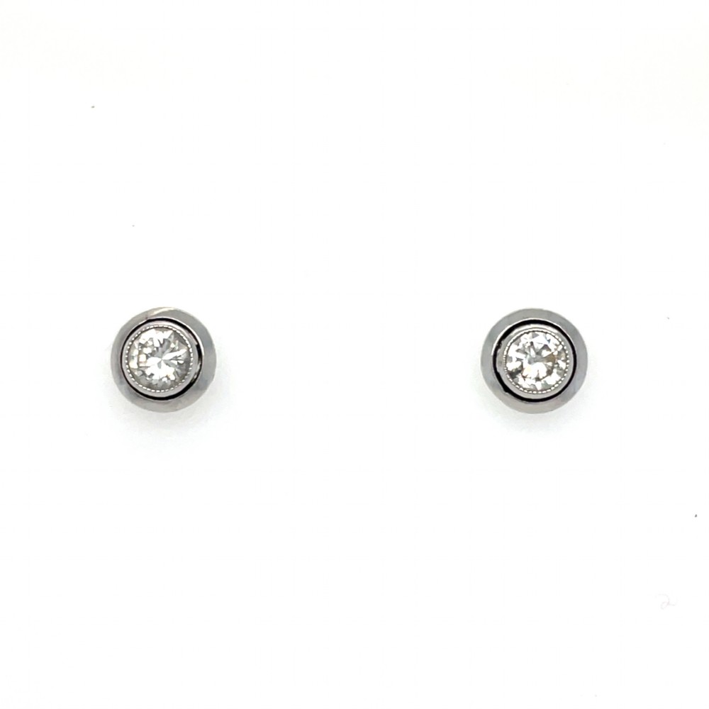 A pair of platinum stud earrings featuring round brilliant-cut diamonds set in smooth rub-over bezel mounts with fine millegrain detailing.