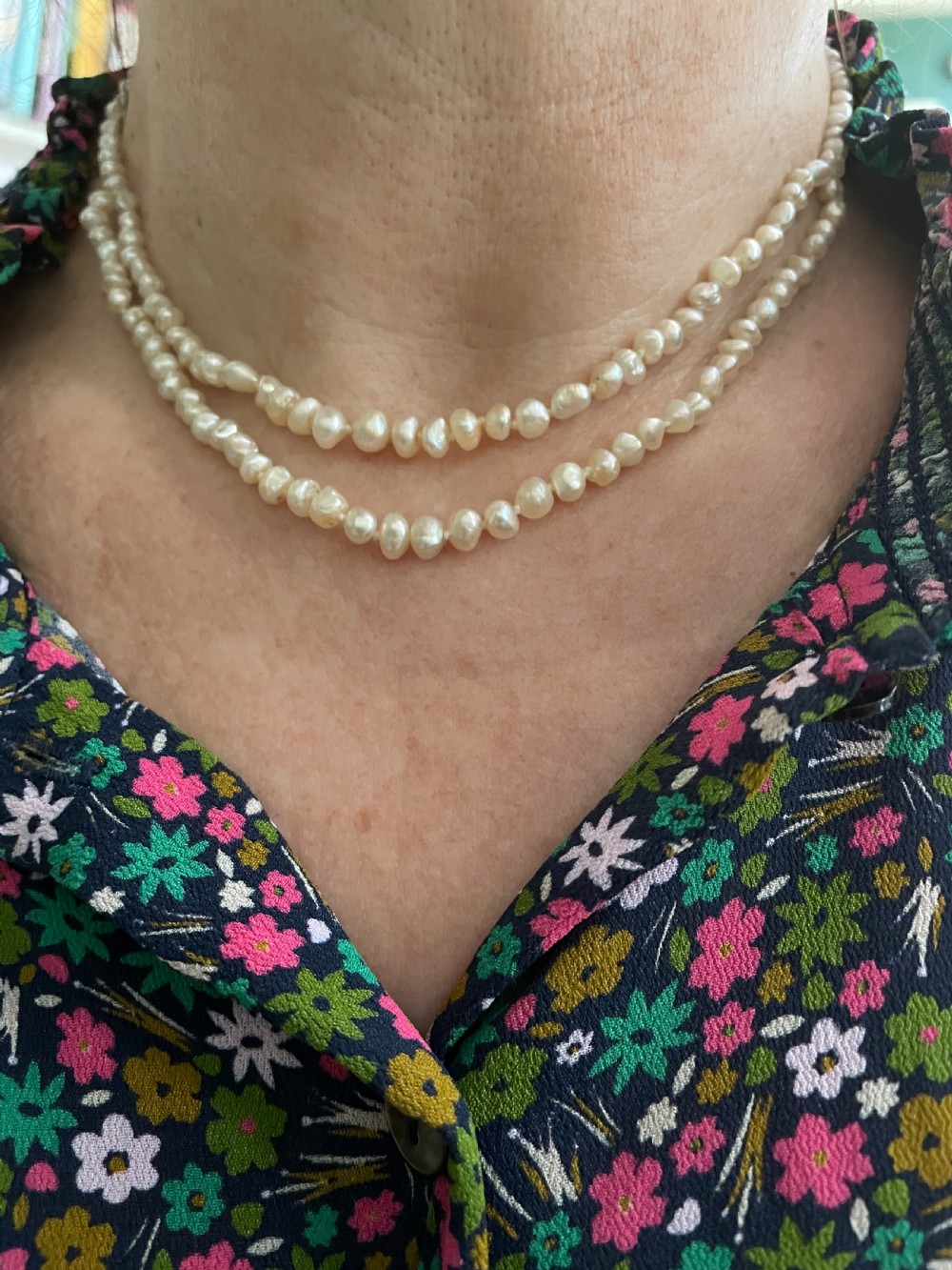 An antique double strand of natural cream pearls connected with an ornate geometric diamond-set clasp. View III