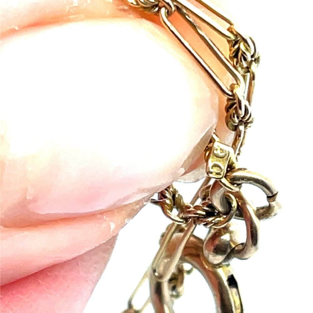 An Edwardian 9ct yellow gold longuard chain featuring elongated links, twisted wire connectors, green gemstone beads, and a circular bolt ring fastener. View III