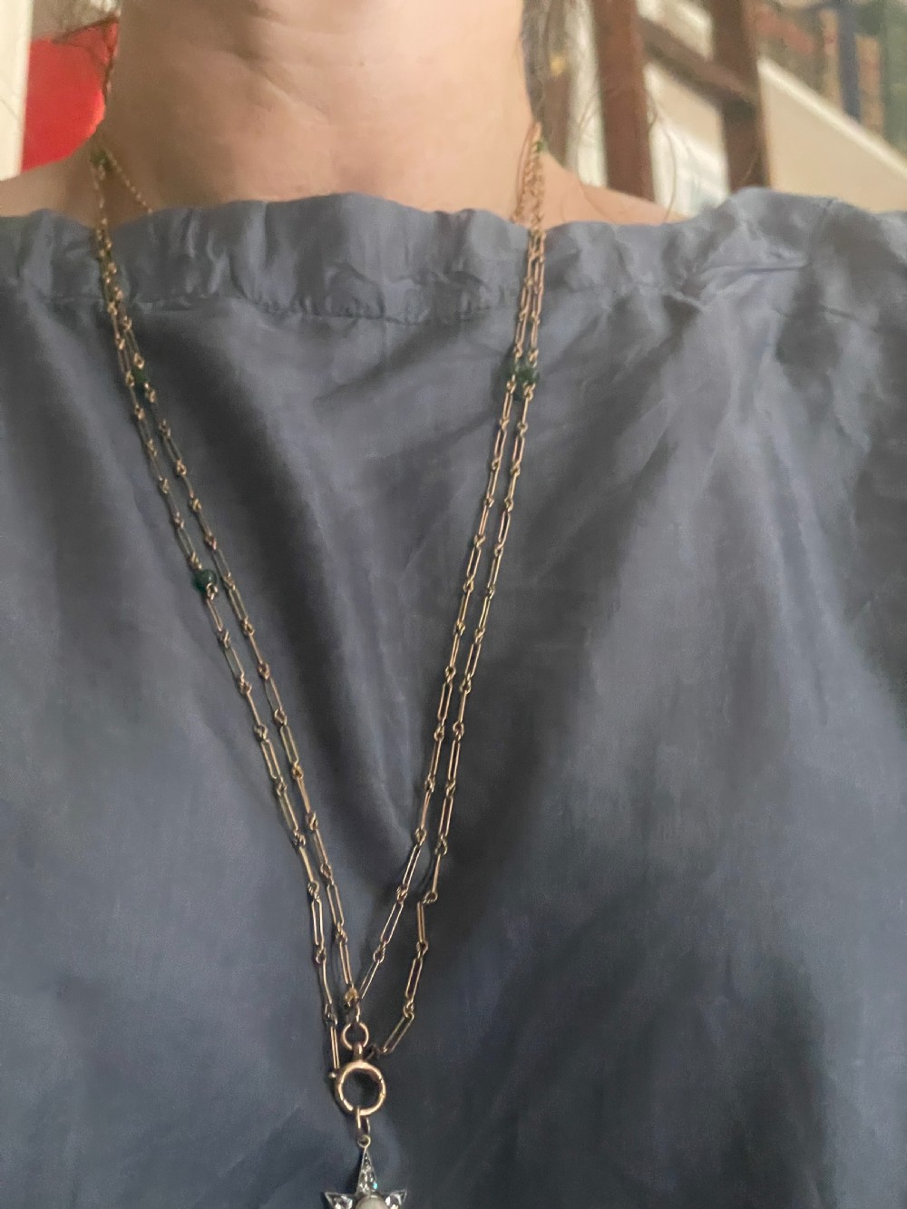 An Edwardian 9ct yellow gold longuard chain featuring elongated links, twisted wire connectors, green gemstone beads, and a circular bolt ring fastener. View IV