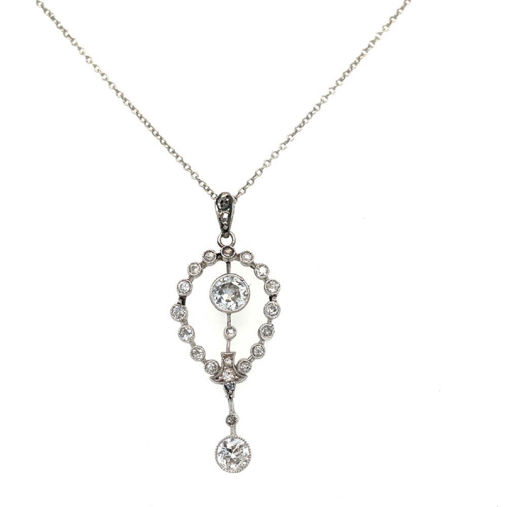 An Edwardian platinum and diamond drop pendant featuring an openwork oval bezel set with old-cut diamonds and an articulated center stone. View II