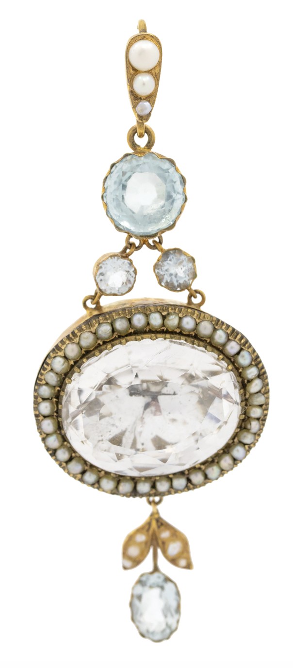 A Victorian gold pendant featuring a large oval rock crystal bordered by split seed pearls, flanked by pale blue aquamarine stones and leaf motifs. View V