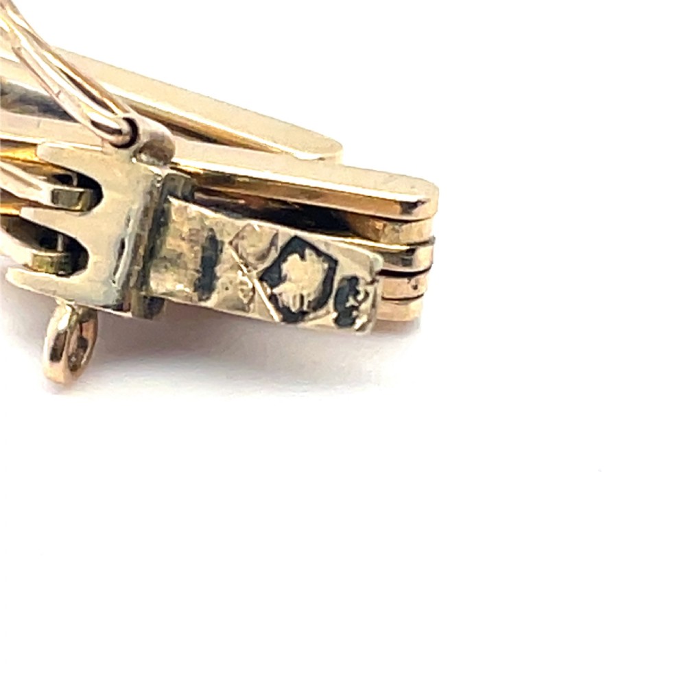An Art Deco 14ct gold link bracelet featuring three geometric square-framed settings mounted with round diamonds. View IV