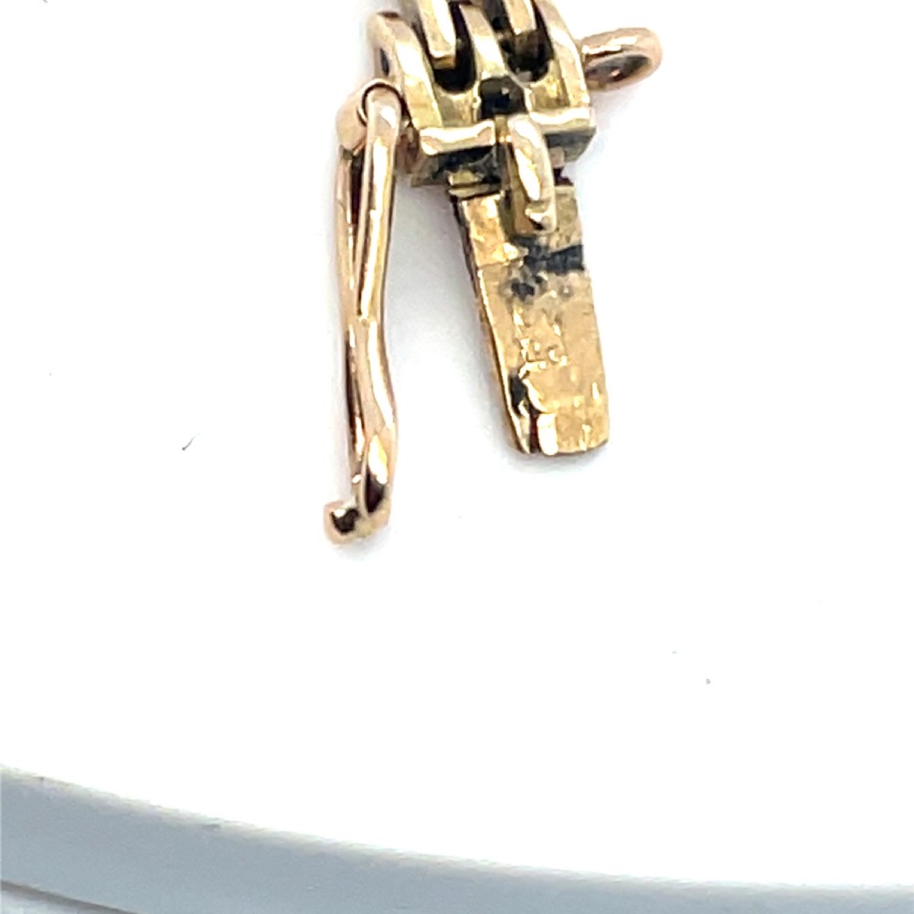 An Art Deco 14ct gold link bracelet featuring three geometric square-framed settings mounted with round diamonds. View V