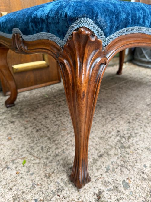 fig 1. A mid-19th-century centre stool featuring carved walnut cabriole legs, carved aprons, and blue velvet upholstered top.