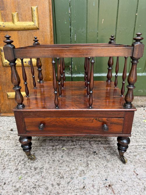fig 1. An early nineteenth-century George IV rosewood music canterbury featuring turned spindle divisions, a single base drawer, turned legs, and brass castors.