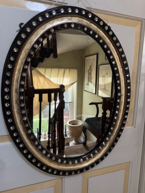 Early C19th Irish Ebonised and Parcel Silver-gilt Oval Framed Mirror with Applied Glass Decoration.