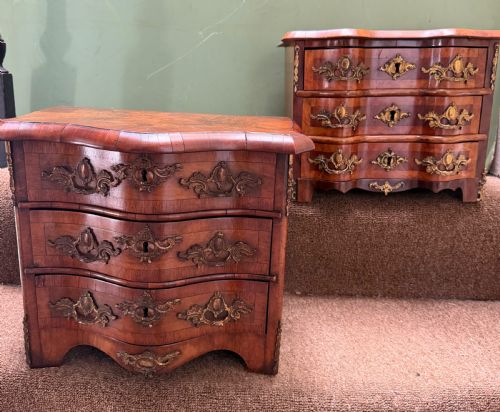 fig 1. A matched pair of late nineteenth-century French miniature walnut commodes featuring serpentine three-drawer fronts and cast gilt-bronze mounts.