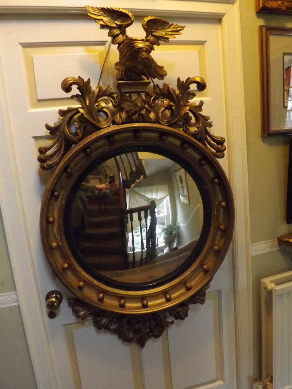 Early C19th Regency period carved gilt-wood framed convex mirror.