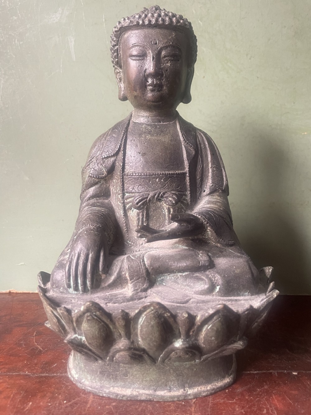 A late 19th-century cast bronze Buddha figure depicted in a seated lotus position on an engraved lotus throne.