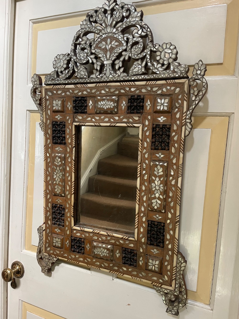 An antique Levantine walnut wall mirror featuring hand-carved decorative cresting and elaborate geometric mother-of-pearl and bone inlay. View III