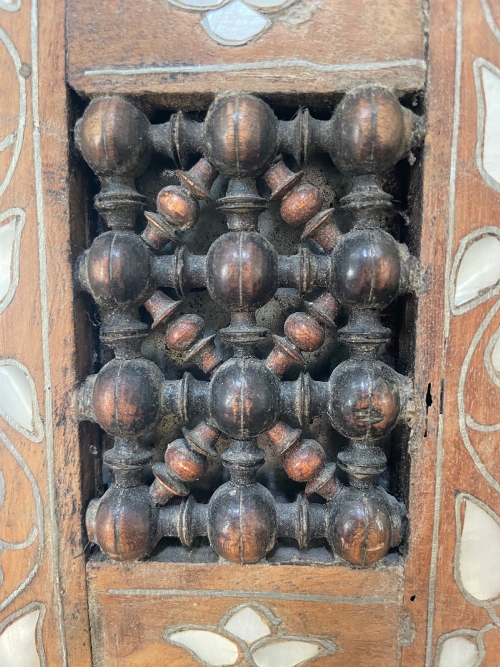 An antique Levantine walnut wall mirror featuring hand-carved decorative cresting and elaborate geometric mother-of-pearl and bone inlay. View VI