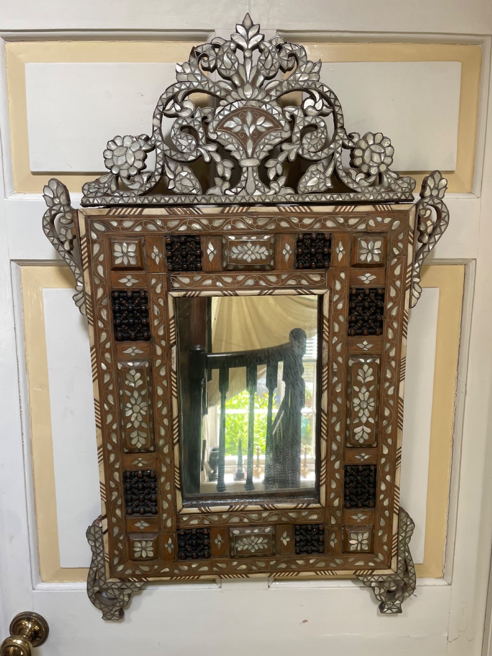 An antique Levantine walnut wall mirror featuring hand-carved decorative cresting and elaborate geometric mother-of-pearl and bone inlay. View X