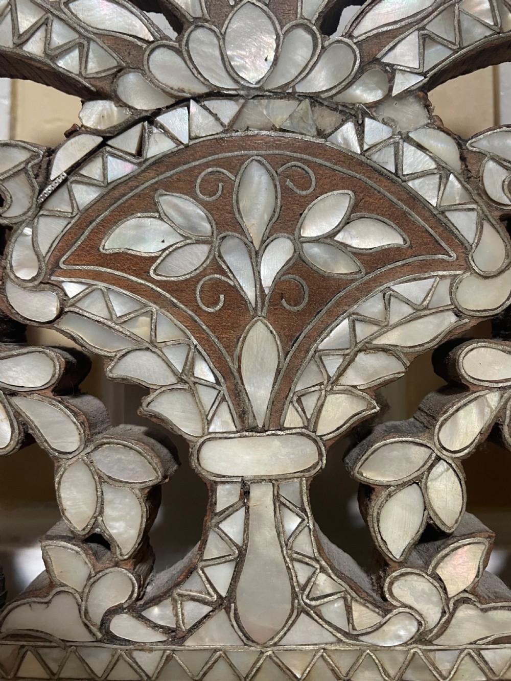 An antique Levantine walnut wall mirror featuring hand-carved decorative cresting and elaborate geometric mother-of-pearl and bone inlay. View XIII