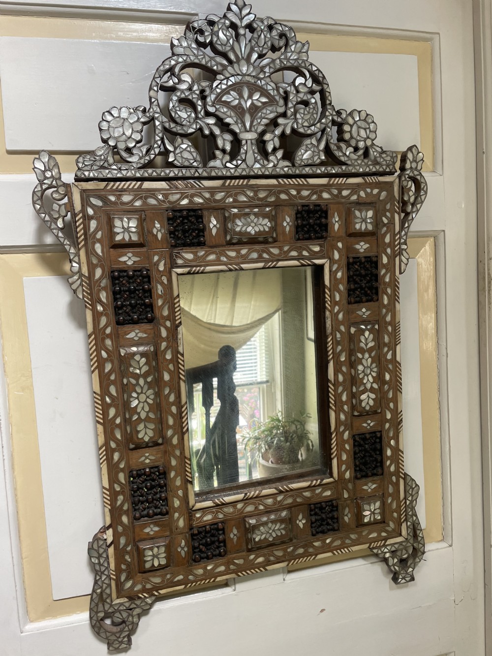 An antique Levantine walnut wall mirror featuring hand-carved decorative cresting and elaborate geometric mother-of-pearl and bone inlay. View XIV