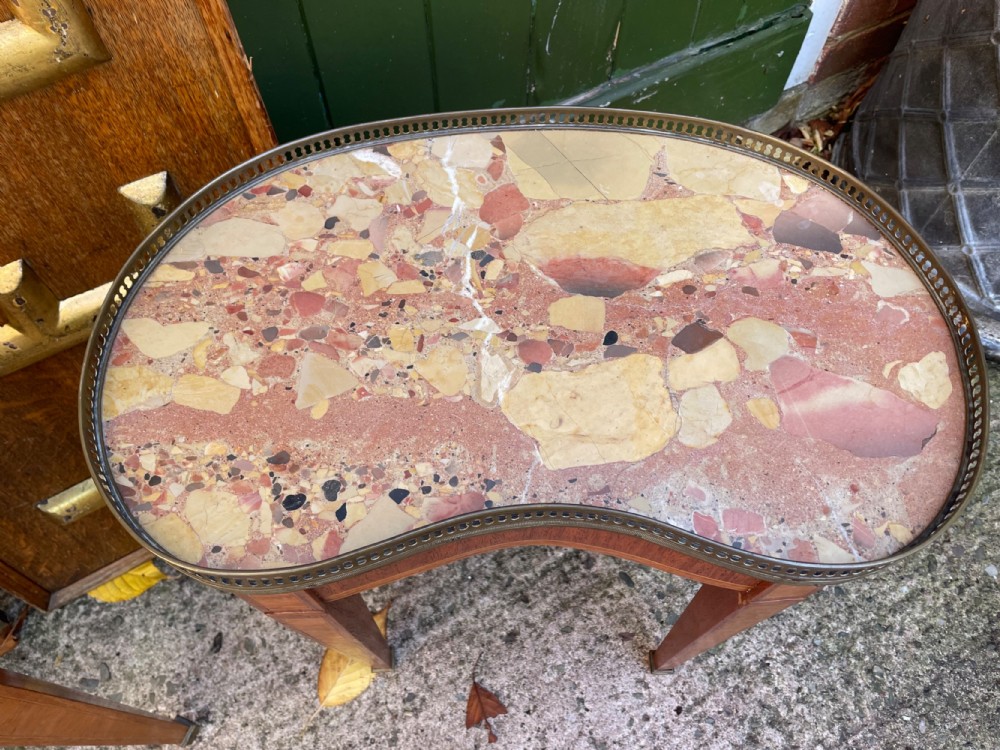 A pair of early twentieth-century French kidney-shaped side tables made from walnut and kingwood with brass galleried marble tops and tapered legs. View VI