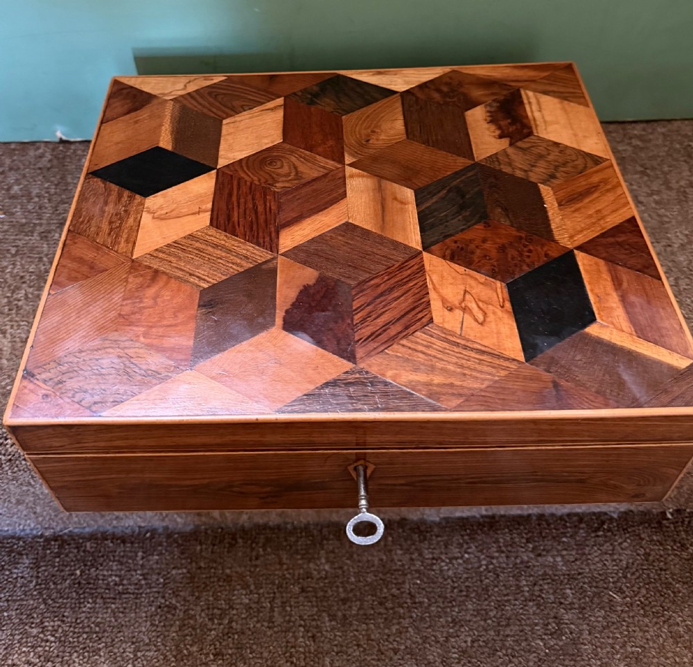 A nineteenth-century rectangular rosewood box featuring a geometric specimen wood parquetry lid and a central keyhole. View IV
