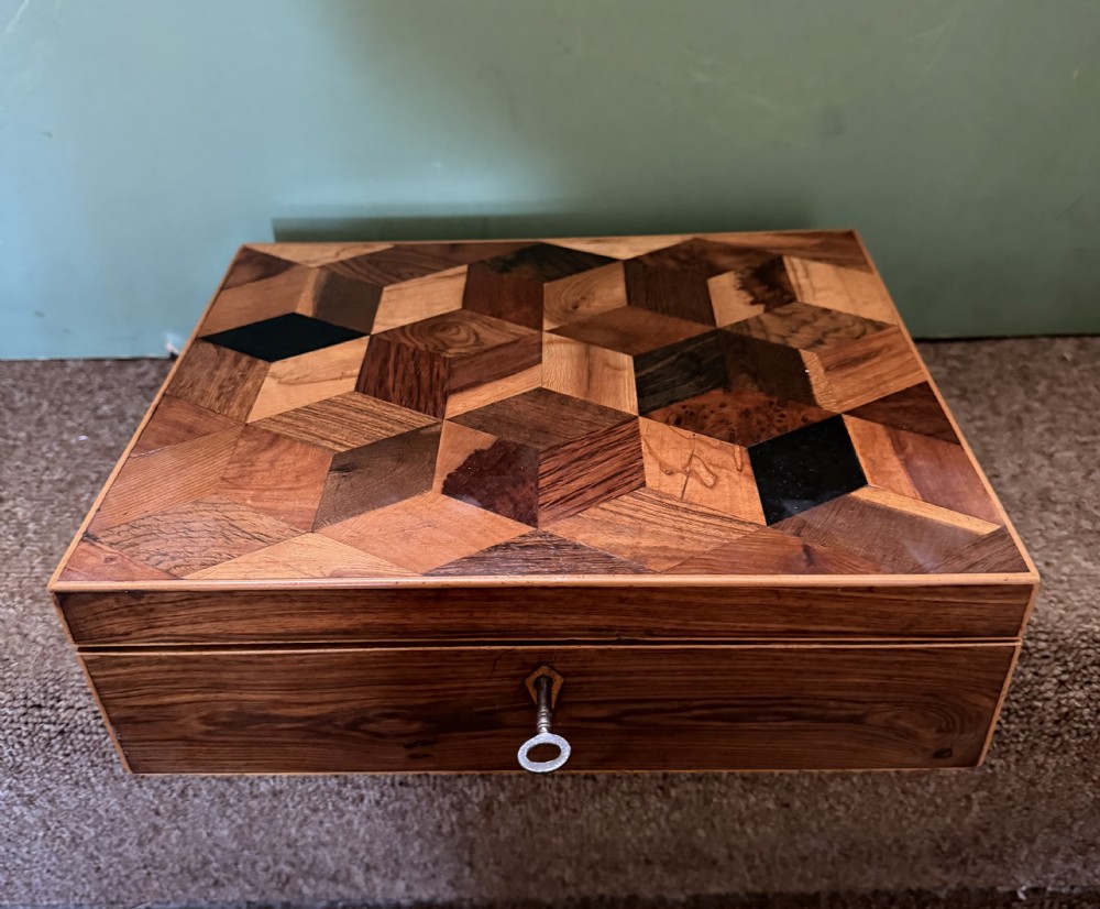 A nineteenth-century rectangular rosewood box featuring a geometric specimen wood parquetry lid and a central keyhole. View VI