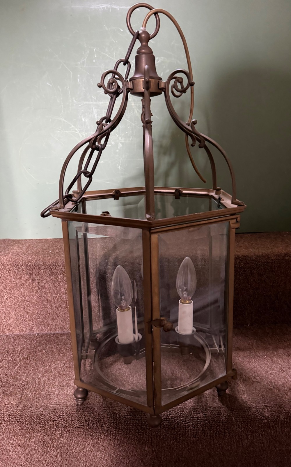 A late nineteenth-century hexagonal brass hanging lantern featuring clear glass panels, scrollwork canopy, and a three-light candle fitting. View IV