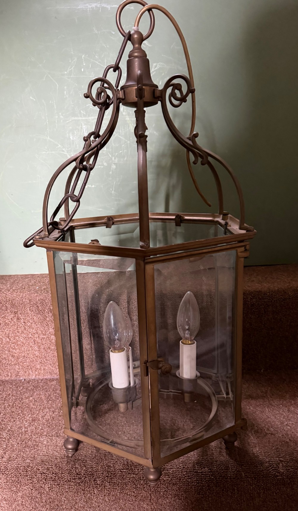 A late nineteenth-century hexagonal brass hanging lantern featuring clear glass panels, scrollwork canopy, and a three-light candle fitting. View VII