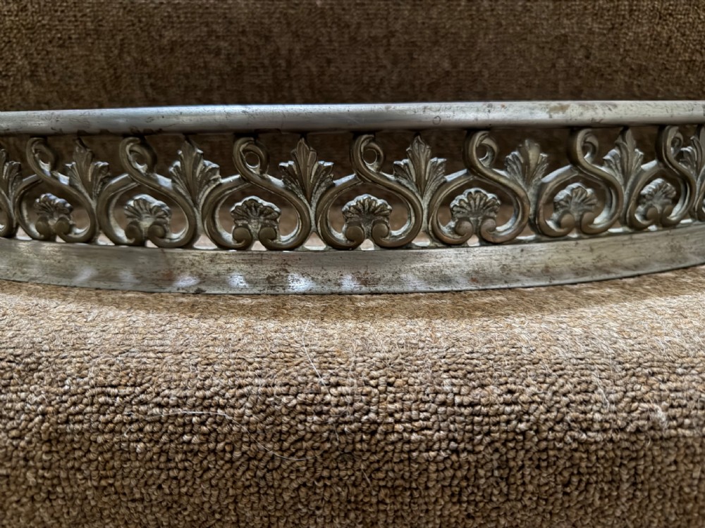 An early 19th-century curved steel fireplace curb featuring openwork Neoclassical cast scrollwork and palmette motifs. View II