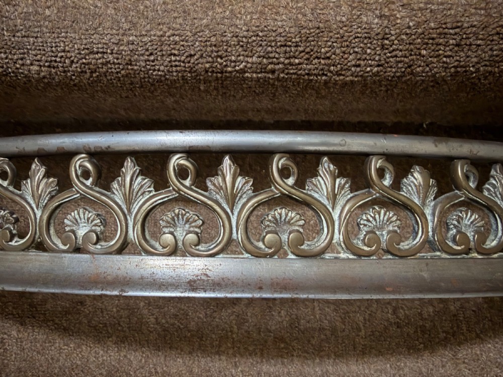 An early 19th-century curved steel fireplace curb featuring openwork Neoclassical cast scrollwork and palmette motifs. View VII