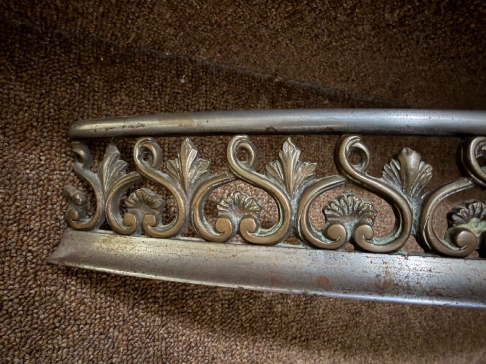 An early 19th-century curved steel fireplace curb featuring openwork Neoclassical cast scrollwork and palmette motifs. View VIII