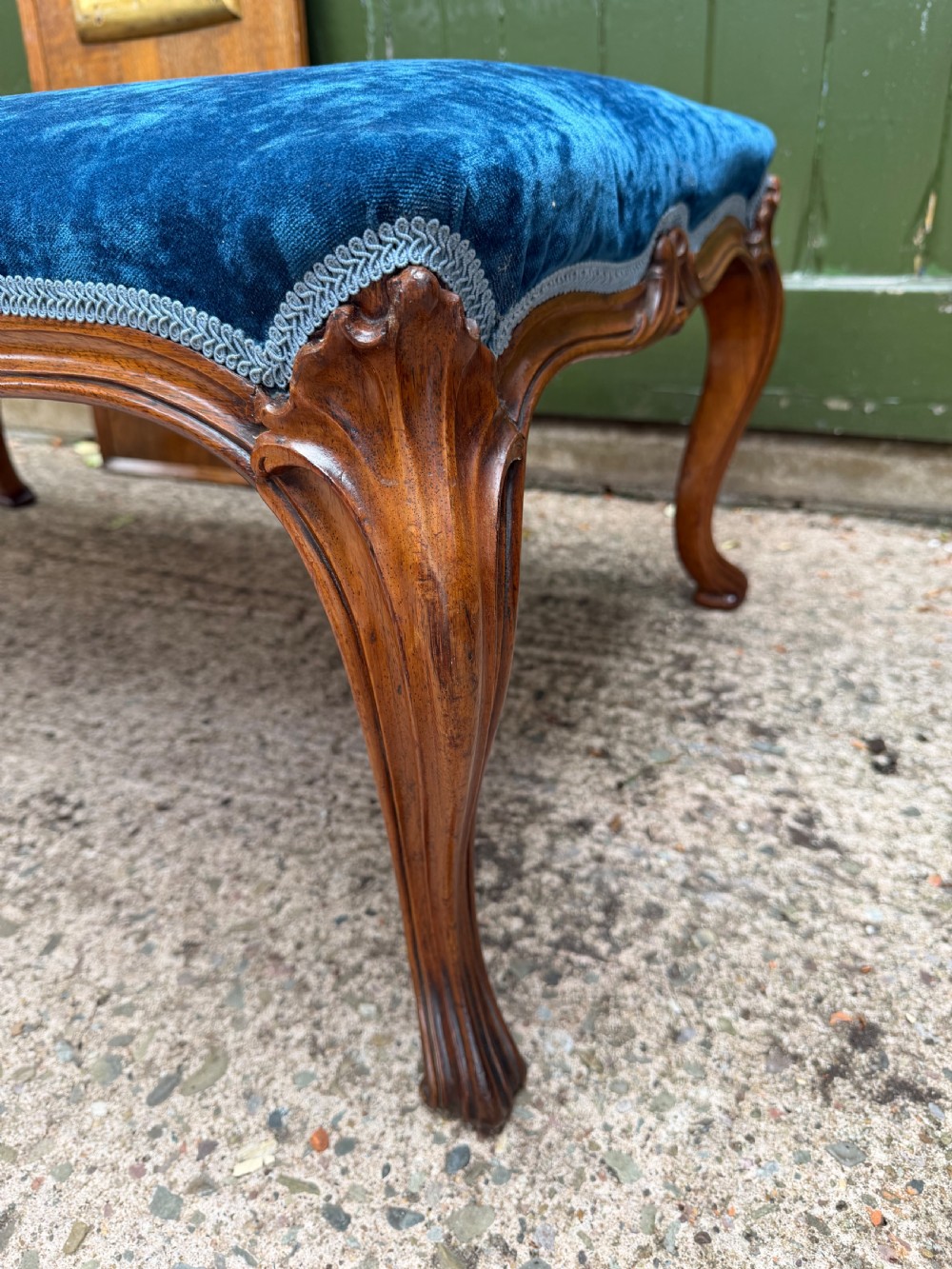 A mid-19th-century centre stool featuring carved walnut cabriole legs, carved aprons, and blue velvet upholstered top. View III