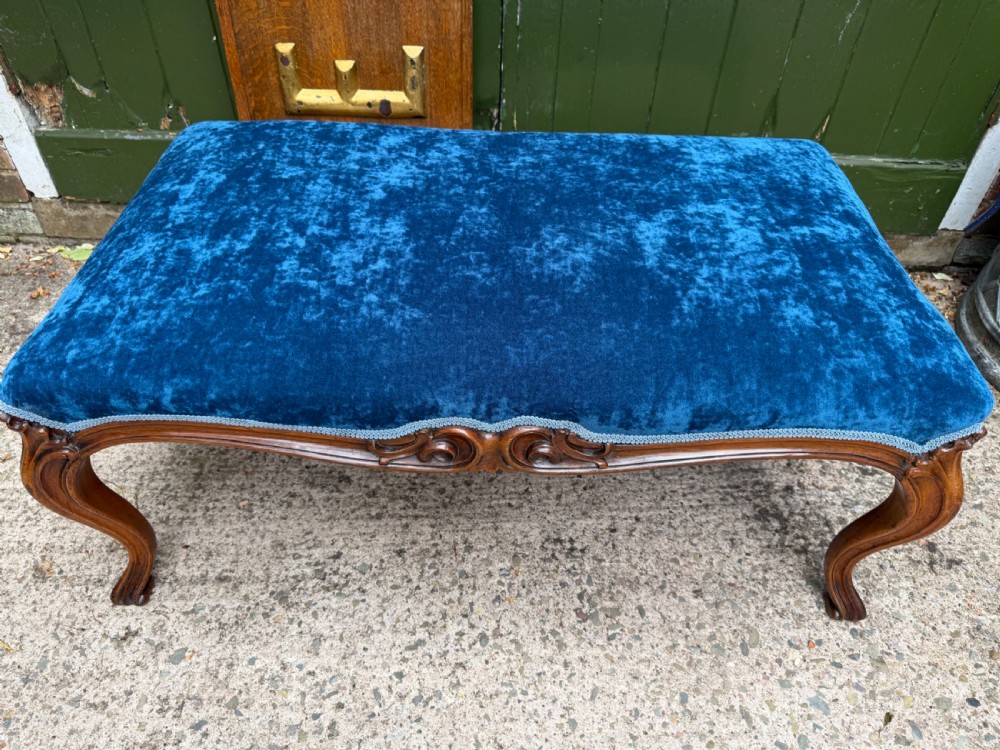 A mid-19th-century centre stool featuring carved walnut cabriole legs, carved aprons, and blue velvet upholstered top. View IV