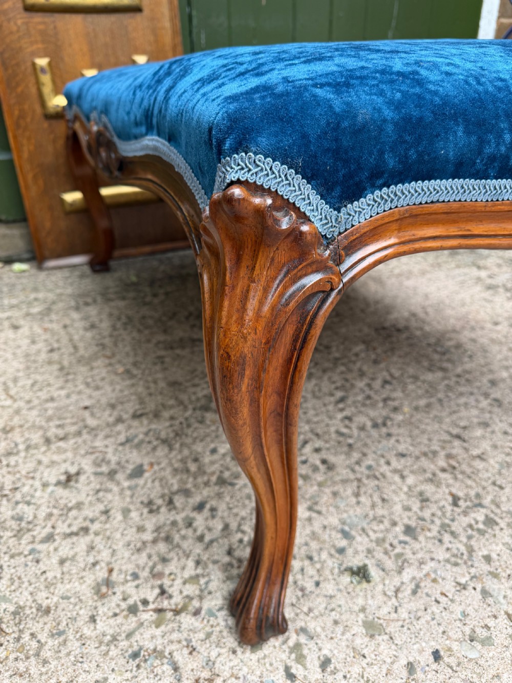 A mid-19th-century centre stool featuring carved walnut cabriole legs, carved aprons, and blue velvet upholstered top. View X