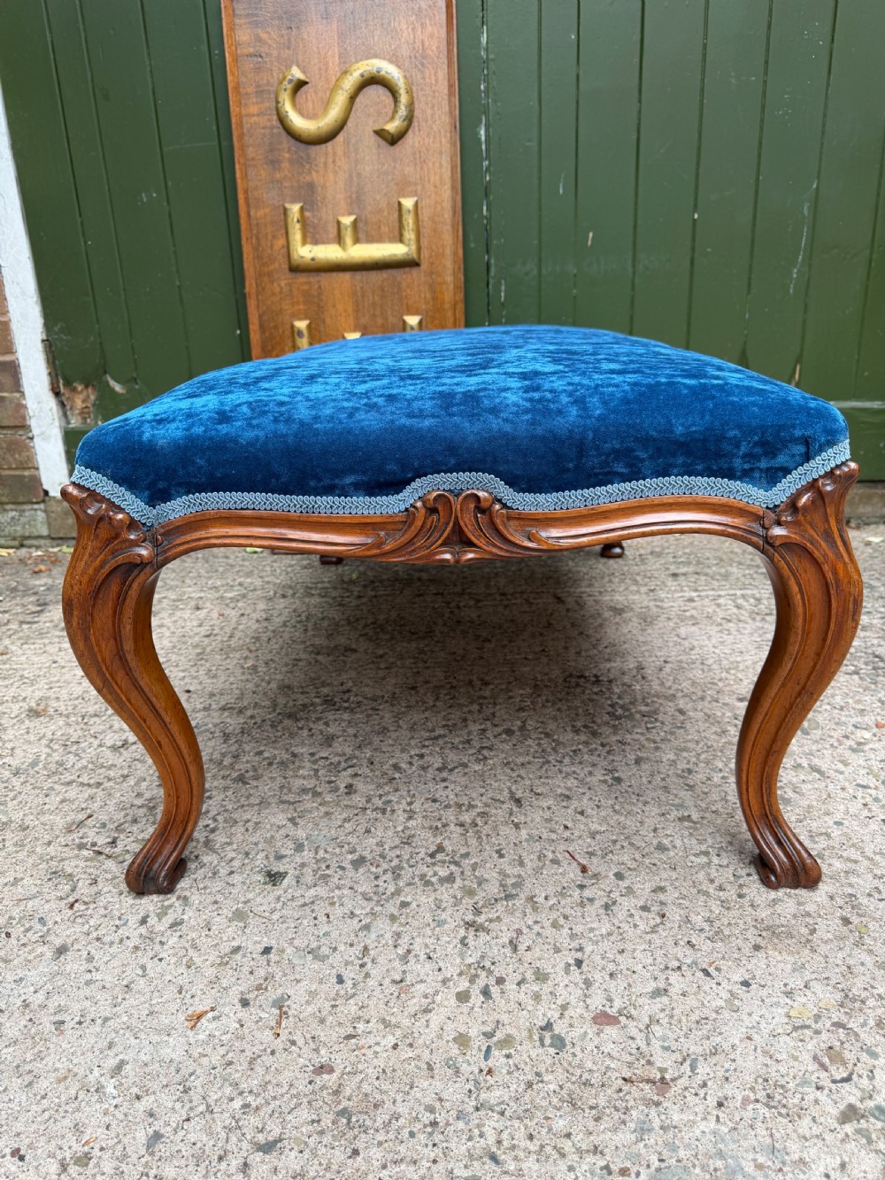 A mid-19th-century centre stool featuring carved walnut cabriole legs, carved aprons, and blue velvet upholstered top. View XI