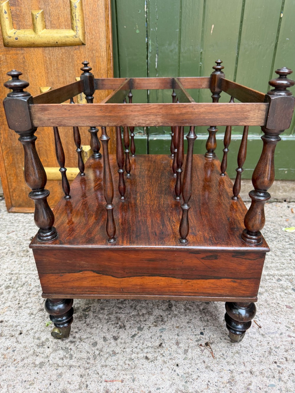 An early nineteenth-century George IV rosewood music canterbury featuring turned spindle divisions, a single base drawer, turned legs, and brass castors. View III