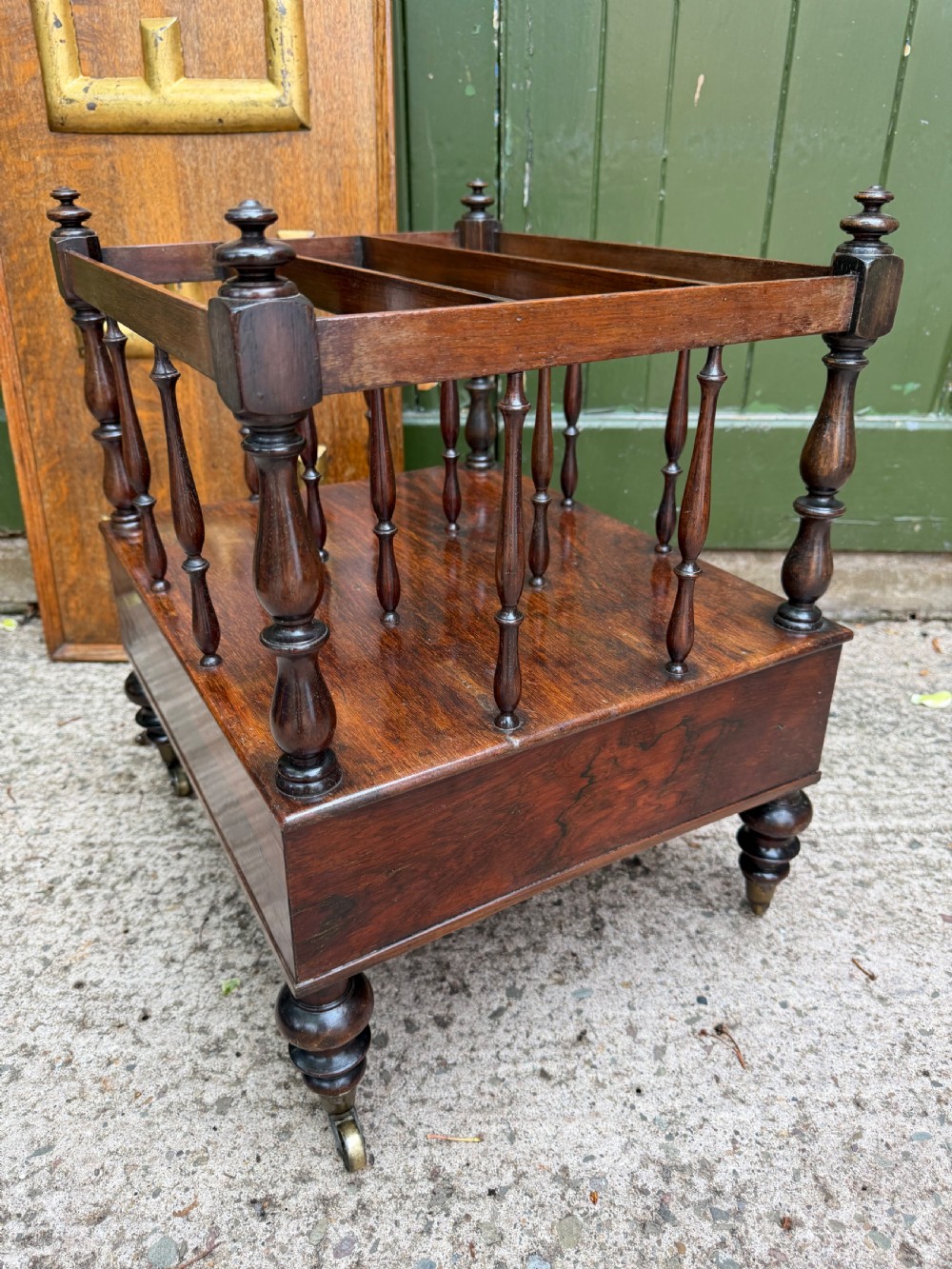An early nineteenth-century George IV rosewood music canterbury featuring turned spindle divisions, a single base drawer, turned legs, and brass castors. View VII