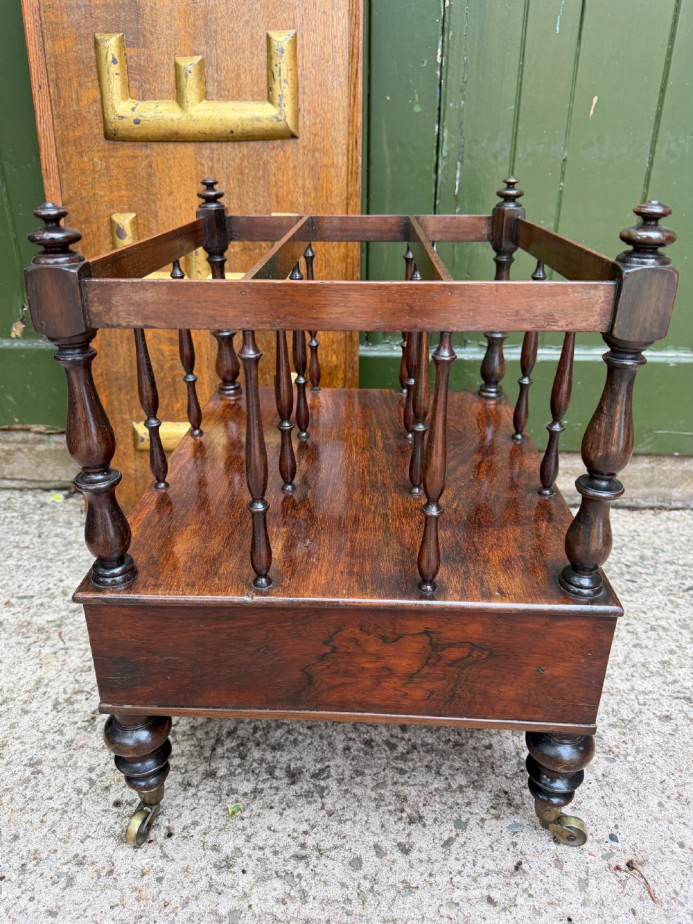 An early nineteenth-century George IV rosewood music canterbury featuring turned spindle divisions, a single base drawer, turned legs, and brass castors. View VIII