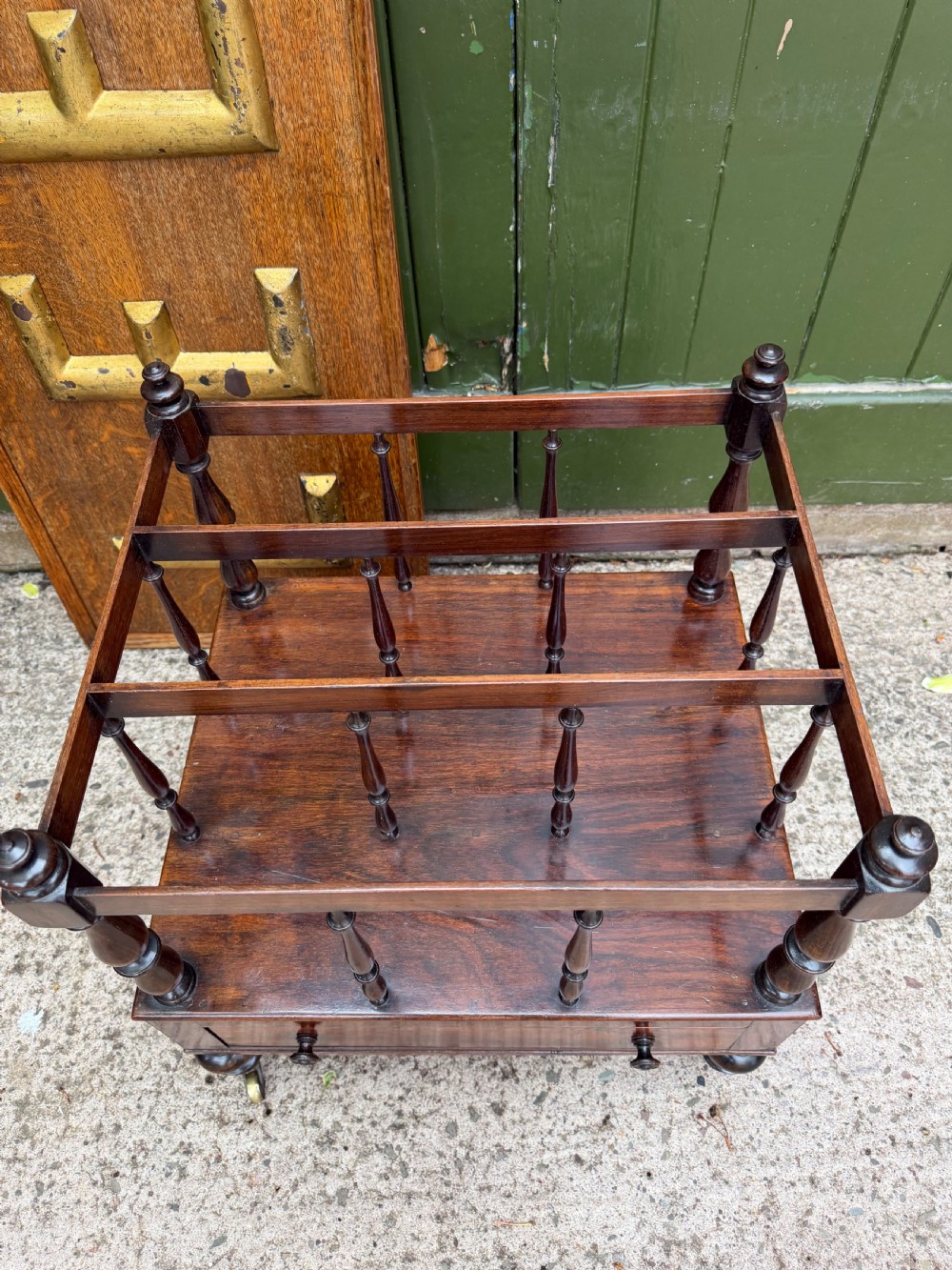 An early nineteenth-century George IV rosewood music canterbury featuring turned spindle divisions, a single base drawer, turned legs, and brass castors. View XII