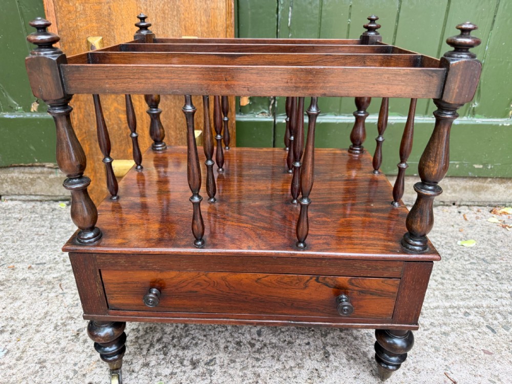 An early nineteenth-century George IV rosewood music canterbury featuring turned spindle divisions, a single base drawer, turned legs, and brass castors. View XIII