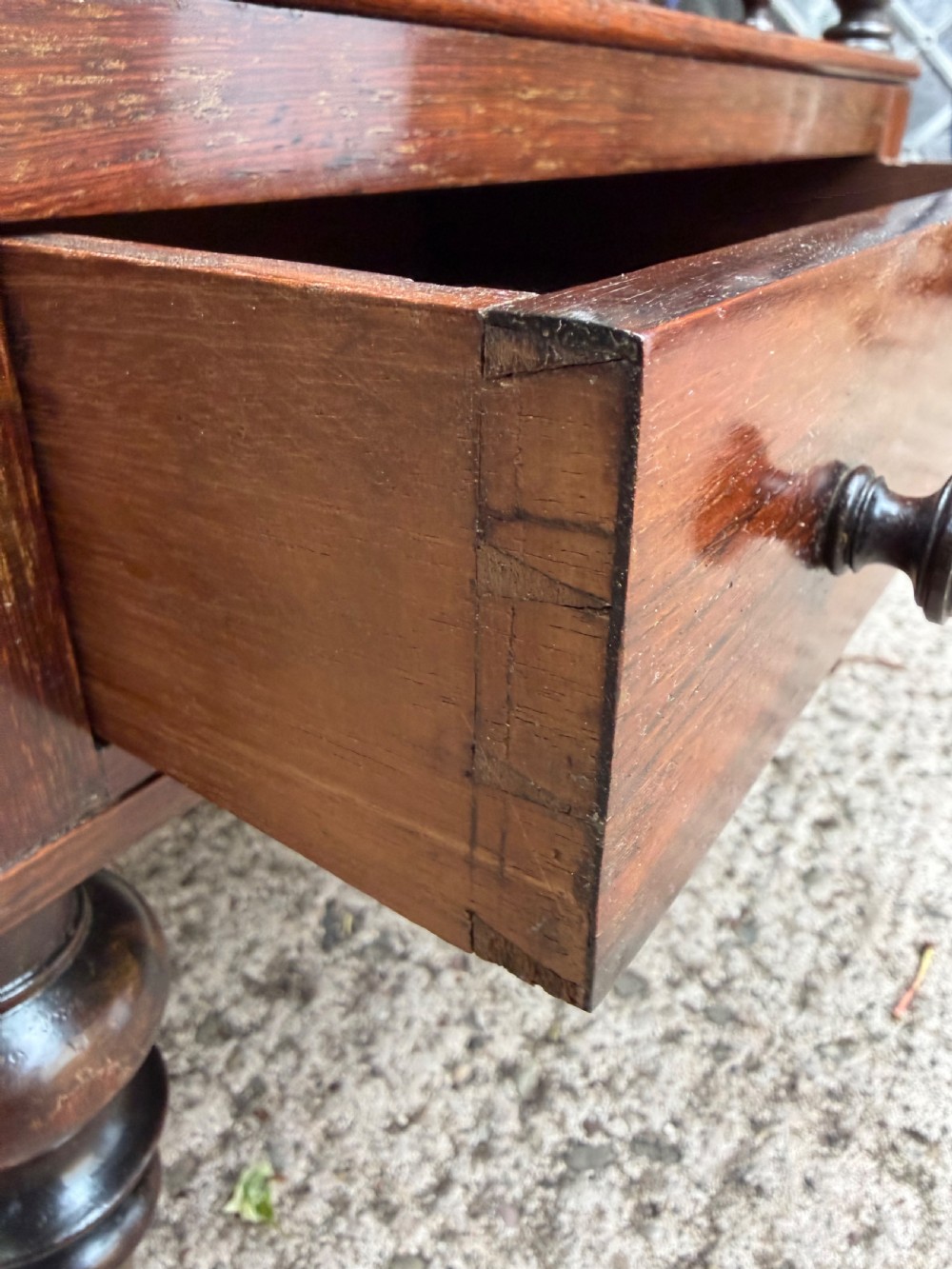 An early nineteenth-century George IV rosewood music canterbury featuring turned spindle divisions, a single base drawer, turned legs, and brass castors. View XIV