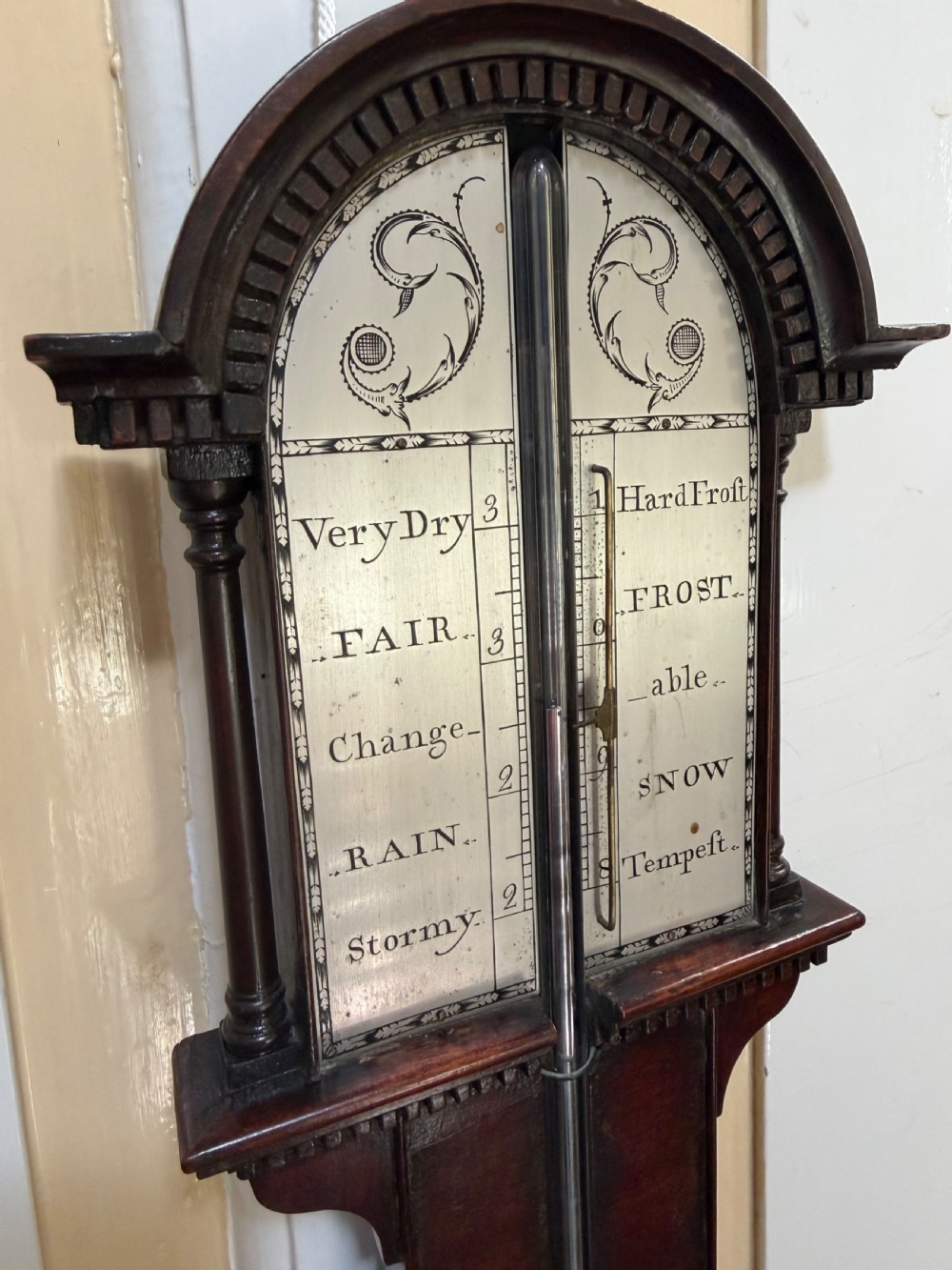 An eighteenth-century George III mahogany stick barometer with an architectural pediment and an engraved silvered dial. View II