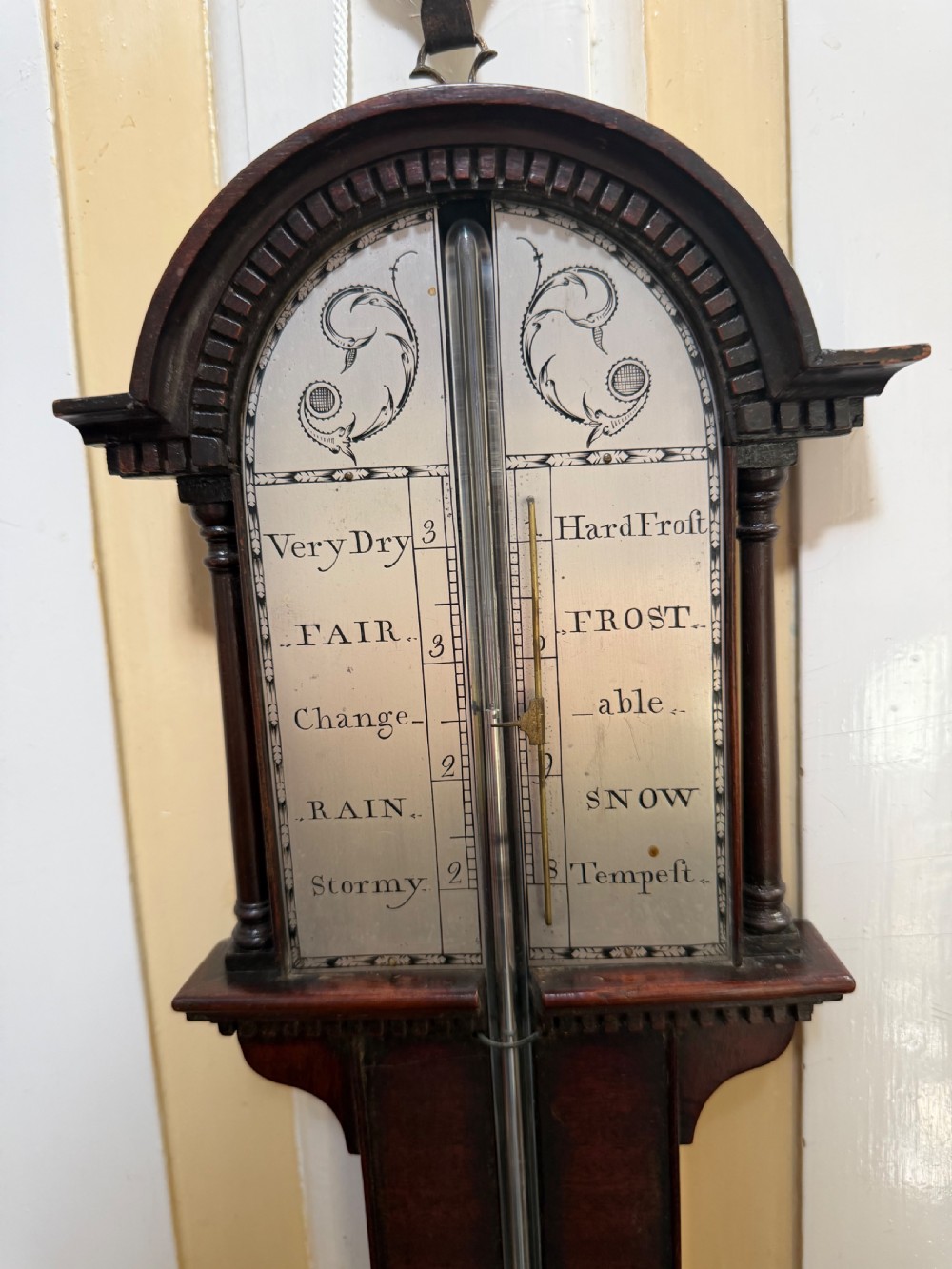 An eighteenth-century George III mahogany stick barometer with an architectural pediment and an engraved silvered dial. View V