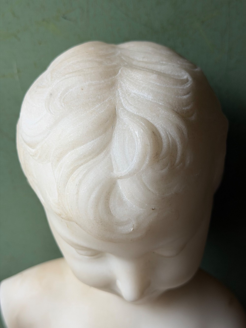 A late nineteenth-century white marble bust of a young boy set upon a dark green turned marble socle base. View XII