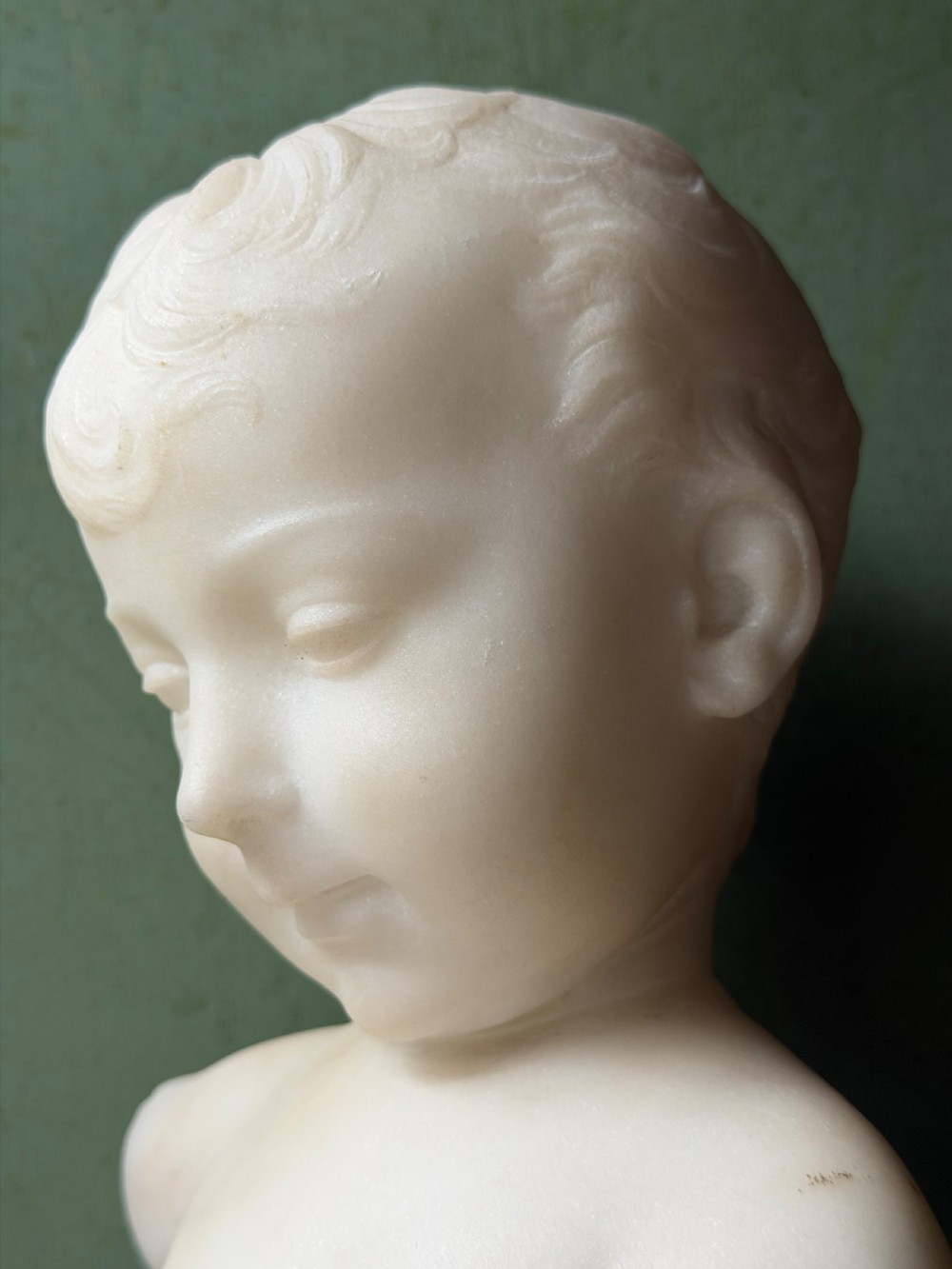 A late nineteenth-century white marble bust of a young boy set upon a dark green turned marble socle base. View XIV