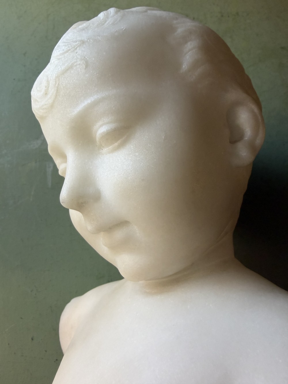 A late nineteenth-century white marble bust of a young boy set upon a dark green turned marble socle base. View XI