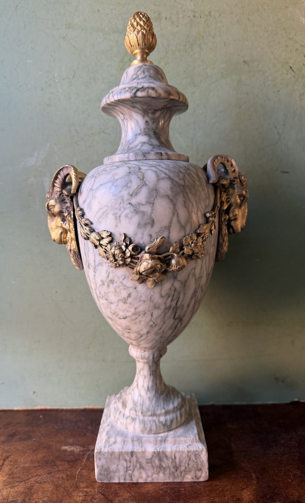 A pair of late 19th-century French Louis XVI style Campan vert marble urns adorned with gilt bronze ram head handles, floral swags, and pinecone finials. View XIII