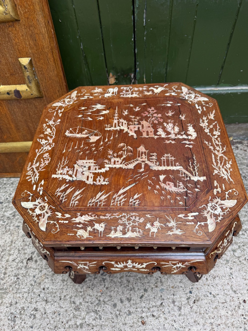 A late 19th-century Chinese dark hardwood occasional table decorated with detailed bone inlay landscape scenes, featuring cabriole legs and a carved apron. View II