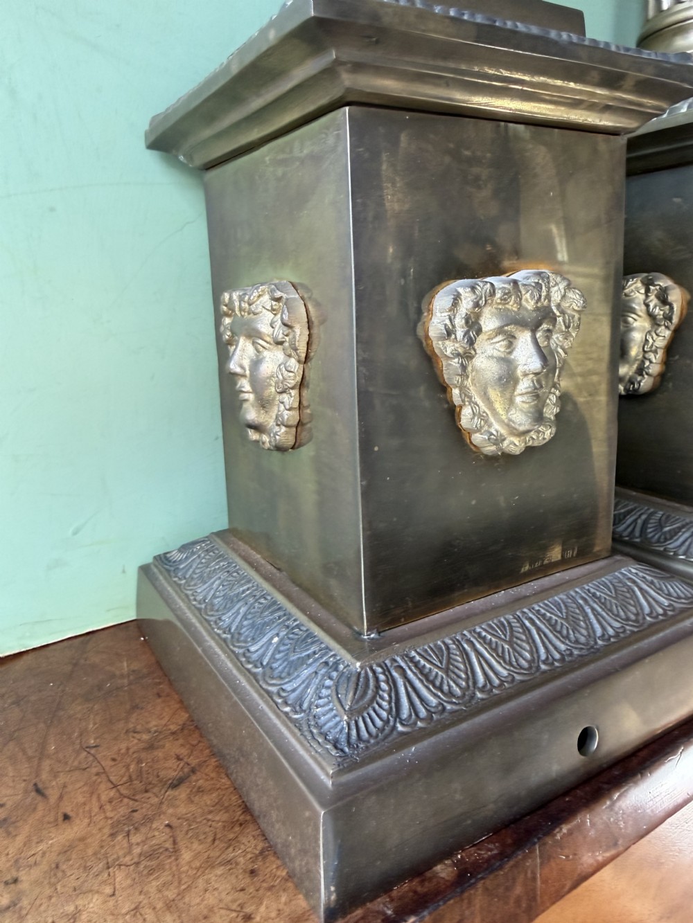 A pair of early twentieth-century brass table lamps featuring fluted classical columns, Corinthian capitals, and square pedestal bases decorated with cast face masks. View XI